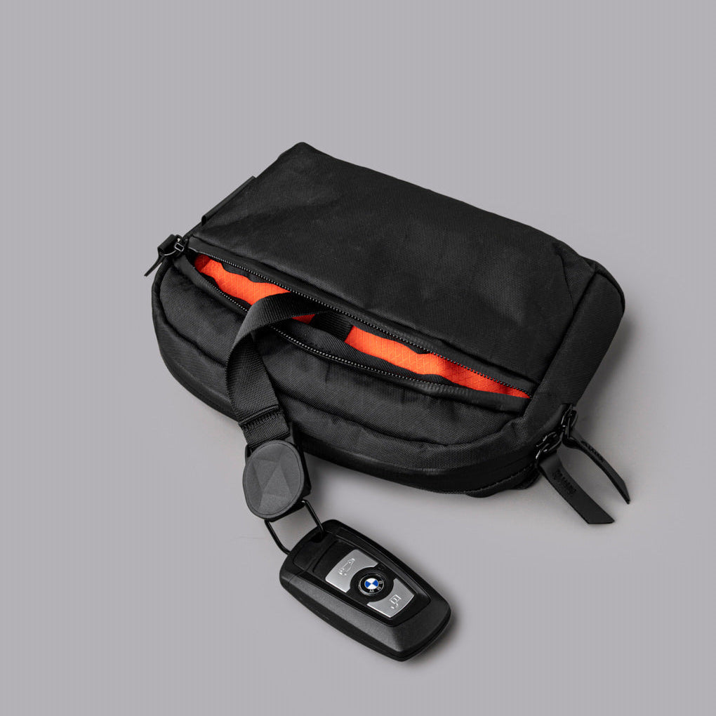 Flight Sling 1L 包內設有分隔收納空間與磁吸鑰匙扣，方便整理物品