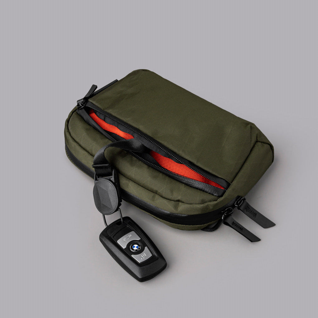 Flight Sling 1L 包內設有分隔收納空間與磁吸鑰匙扣，方便整理物品