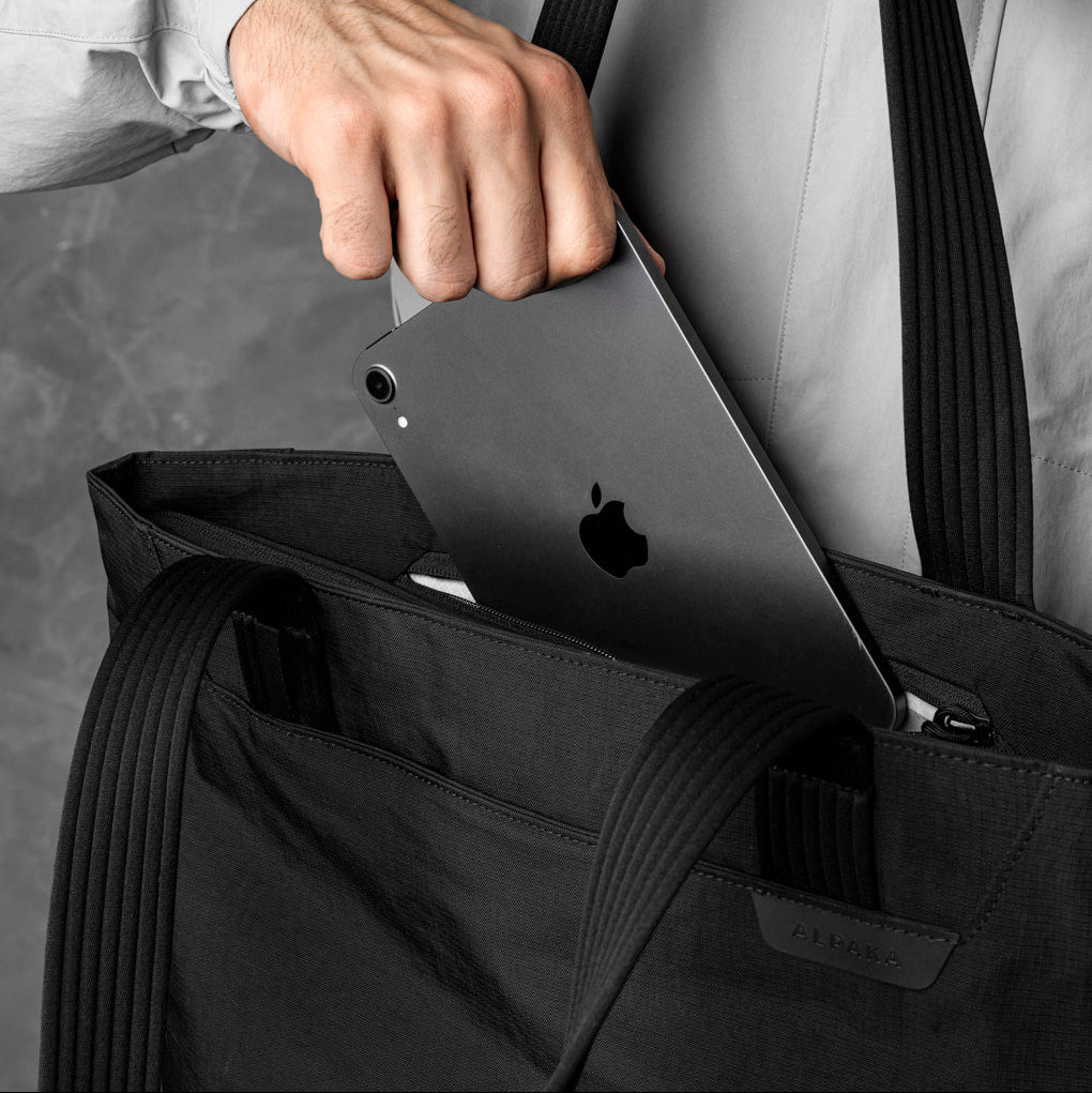 ALPAKA Flight Tote (M) 的內部隔層展示，包括筆記型電腦隔層與水壺隔層。